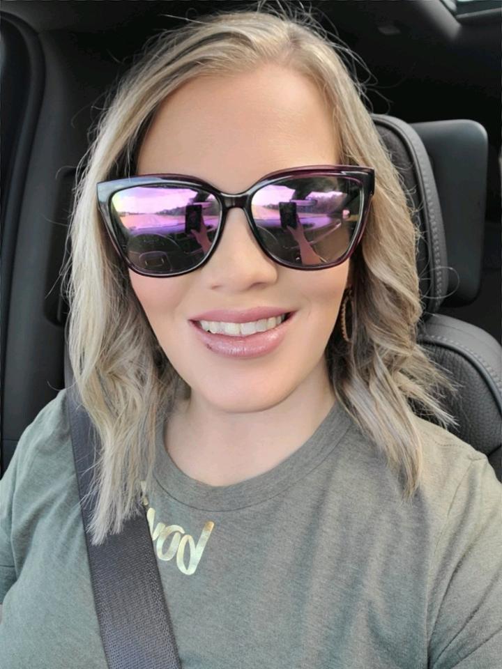 A woman wearing sunglasses in the back seat of a car. by Chasing the Sun Vacations