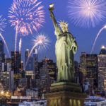 A statue of liberty with fireworks in the background, ideal for travel agents promoting all-inclusive tours. by Chasing the Sun Vacations