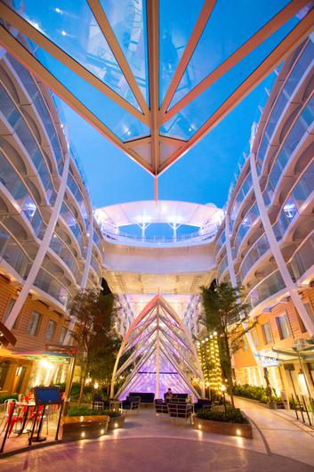 The all-inclusive lobby of a cruise ship at night, where travelers can book their cruise through the travel agency. by Chasing the Sun Vacations