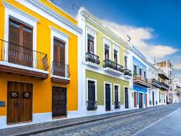 Colorful buildings on a cobblestone street in San Juan, Colombia - a vibrant attraction for travel enthusiasts. by Chasing the Sun Vacations