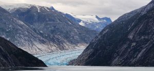 A glacier flowing into a body of water. by Chasing the Sun Vacations