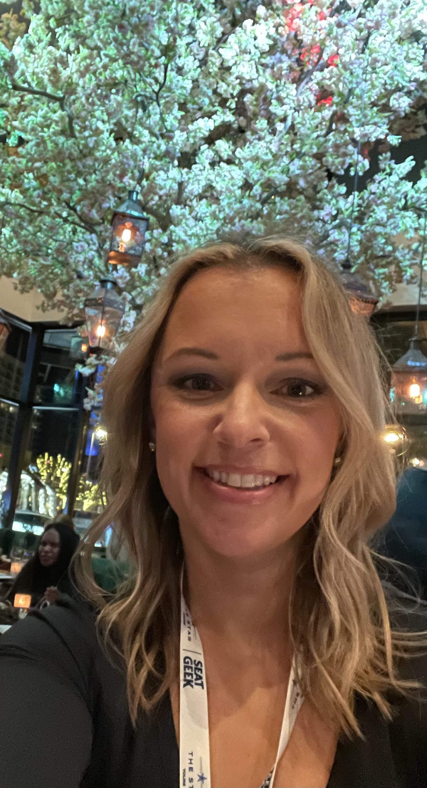 A woman smiling in front of a tree in a restaurant. by Chasing the Sun Vacations